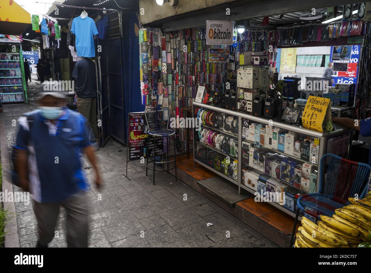 A man walks next to a sign displaying the acceptance of Bitcoin as a  payment method on June 15, 2022 in San Salvador, El Salvador. El Salvador´s  government has experienced losses of
