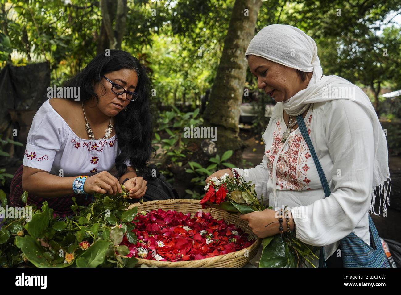 Pipil indigenous community women prepare flowers for an altar during a