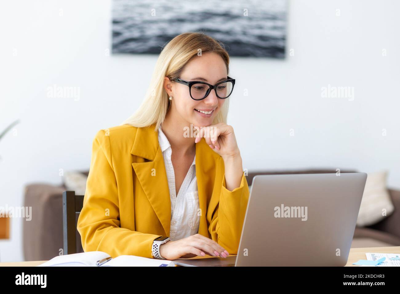 Happy woman entrepreneur sitting at her workplace in the modern office ...