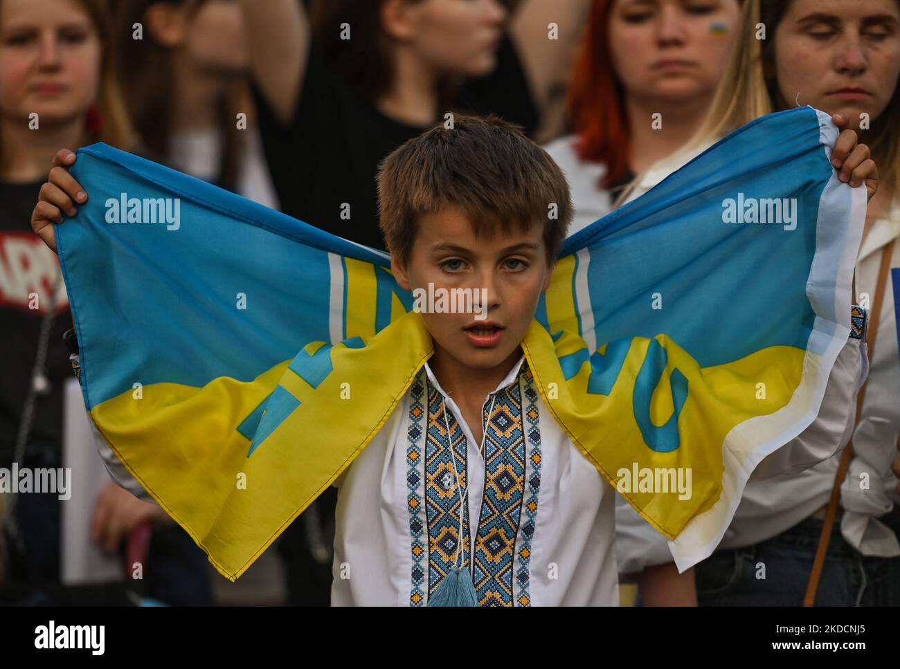 A young protester is holding a Ukrainian flag. Members of the local Ukrainian diaspora, war refugees, peace activists, volunteers and local supporters during the 'Be Brave Like Azovstal Heroes' demonstration in defense of the heroic soldiers of Azovstal on the 122nd day of the war. On Saturday, June 25, 2022, in Main Market Square, Krakow, Poland. (Photo by Artur Widak/NurPhoto) Stock Photo
