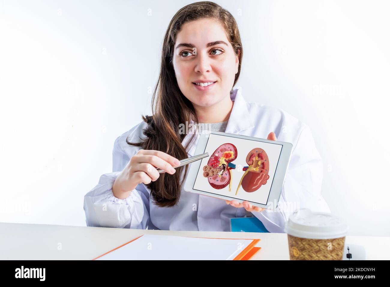 A female urologist showing the shape of a diseased kidney on a tablet