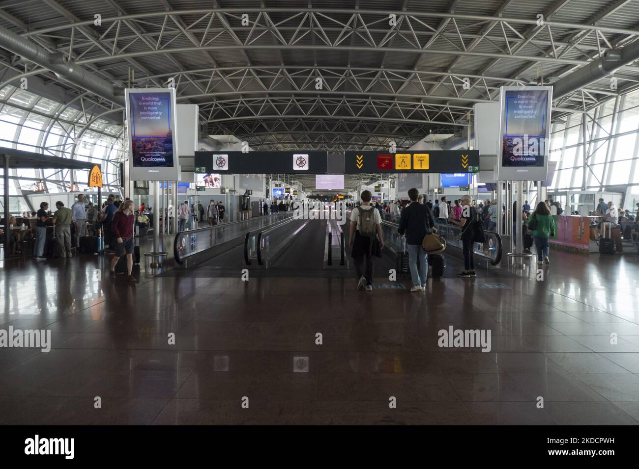 Morning departing and arriving passengers are seen carrying their luggage inside the terminal