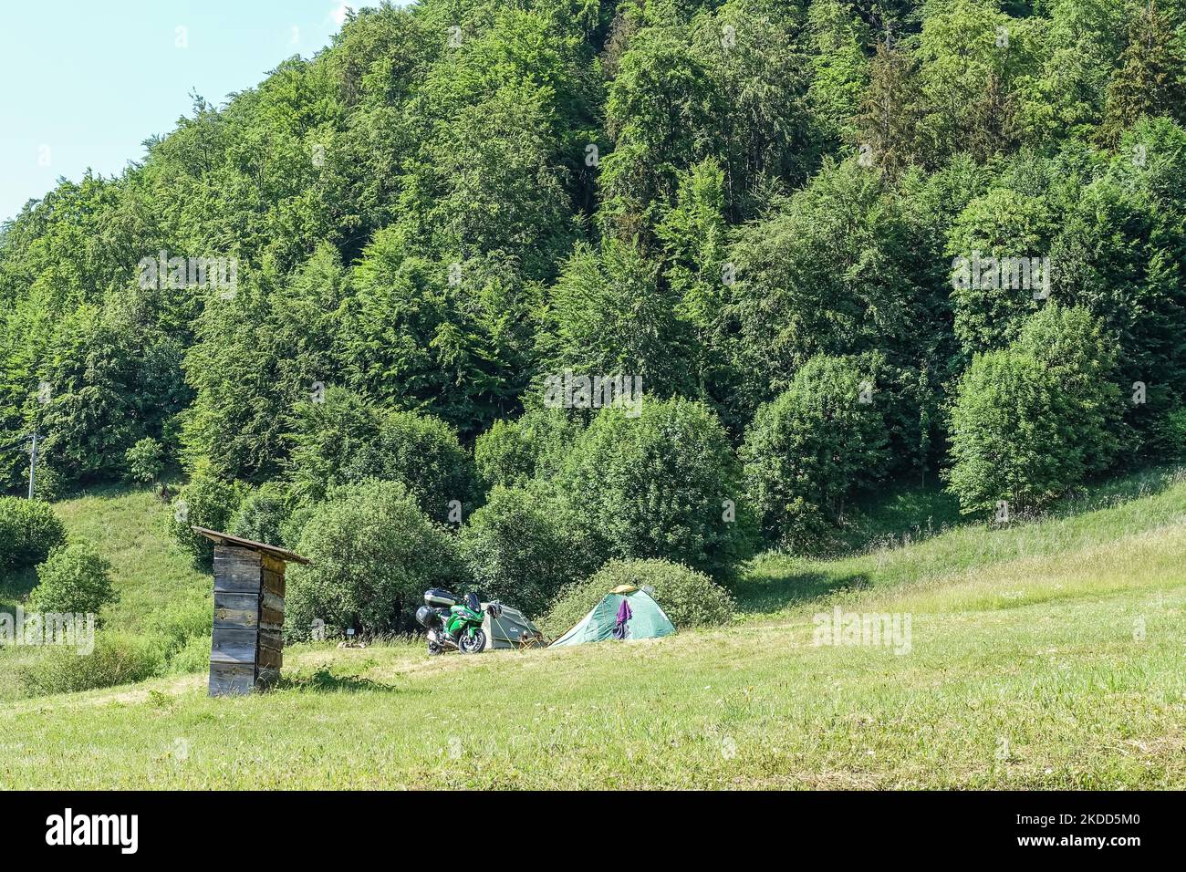 Tents set up on the hillside with a motorcycle in front of them are seen in Dedinky, Slovakia on 16 June 2022 (Photo by Michal Fludra/NurPhoto) Stock Photo