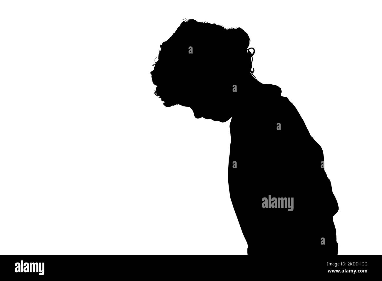 Silhouette of a young boy looking for something on the ground Stock Photo
