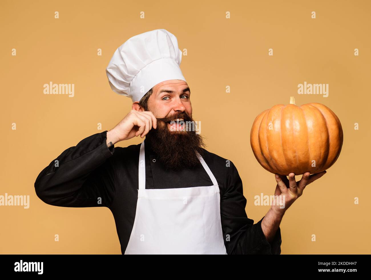Bearded cook in chef hat with pumpkin. Useful vegetable. Seasonal vitamin. Thanksgiving day cooking. Stock Photo