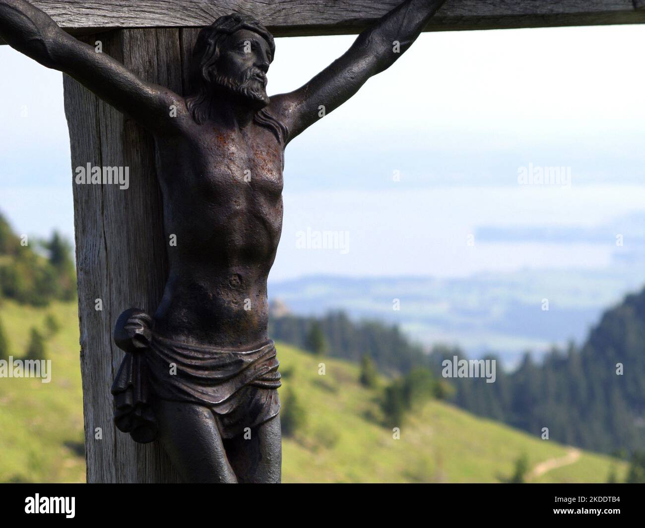 Close-up of wooden crucifix in the bavarian Alps and view to Chiemgau, Bavaria, Germany Stock Photo