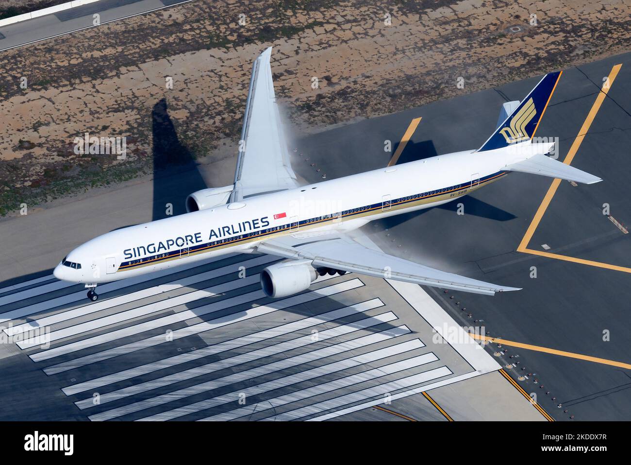 Singapore Airlines Boeing 777 aircraft over runway threshold. Airplane 777-300ER of Singapore Airlines registered as 9V-SWB above runway. Plane B777. Stock Photo
