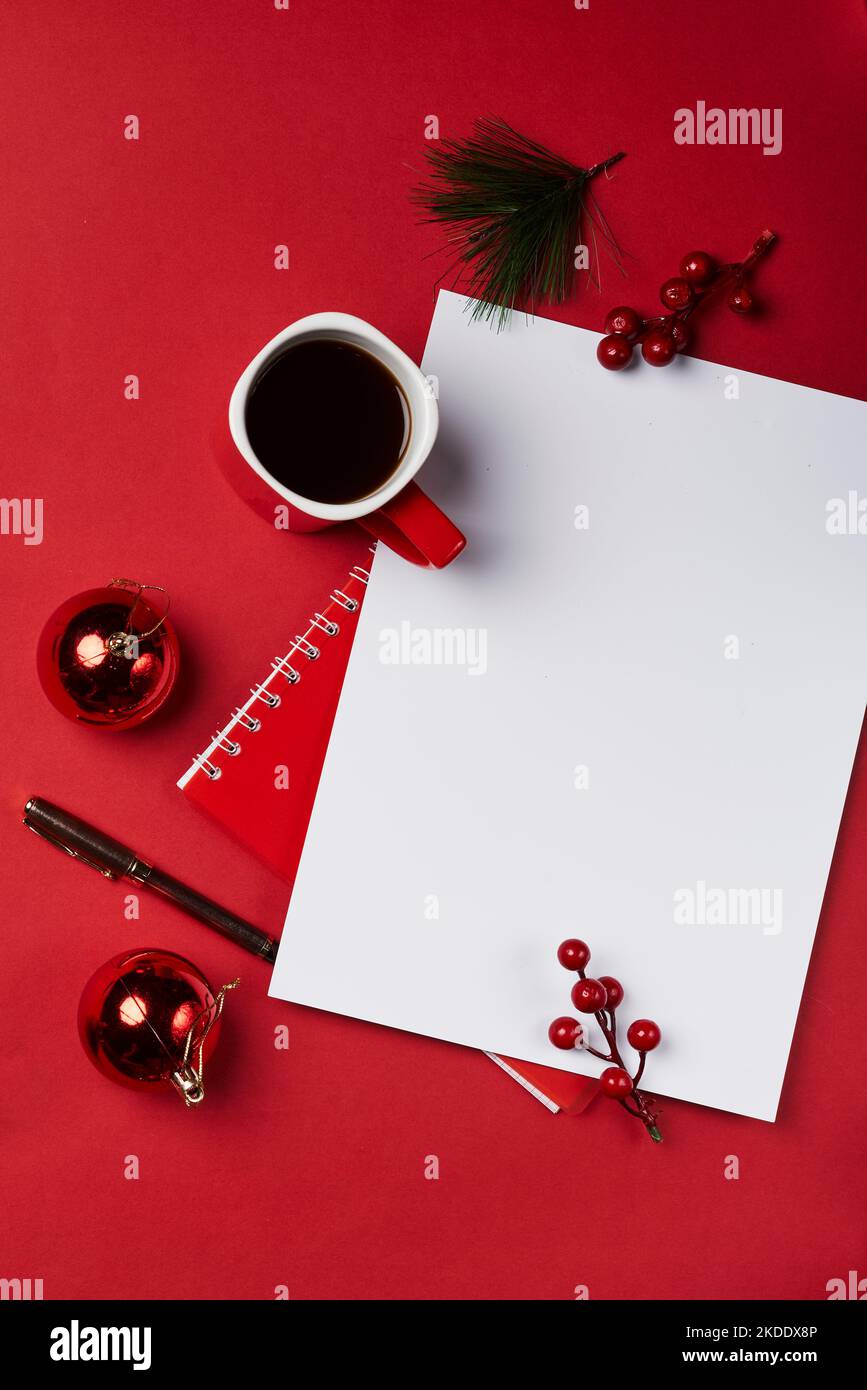 christmas decorations and a cup of coffee on a red background with a blank paper for your own message or text Stock Photo