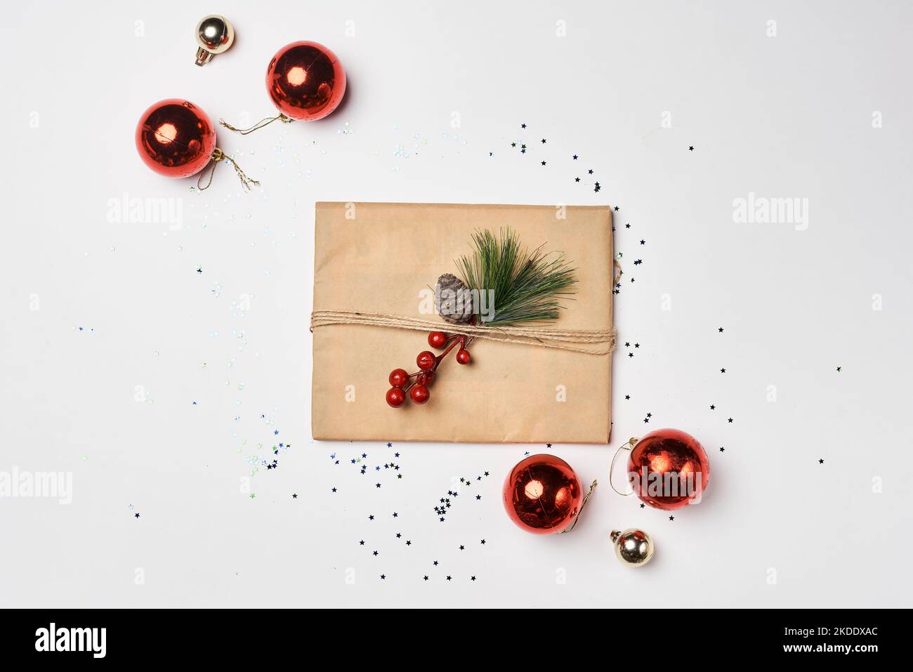 an envelope with christmas decorations around it on a white background, surrounded by confections and pine cones Stock Photo