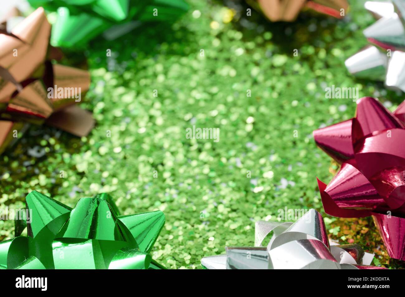 Green glitter background with bow frame of metallic shiny spiky ribbon ...