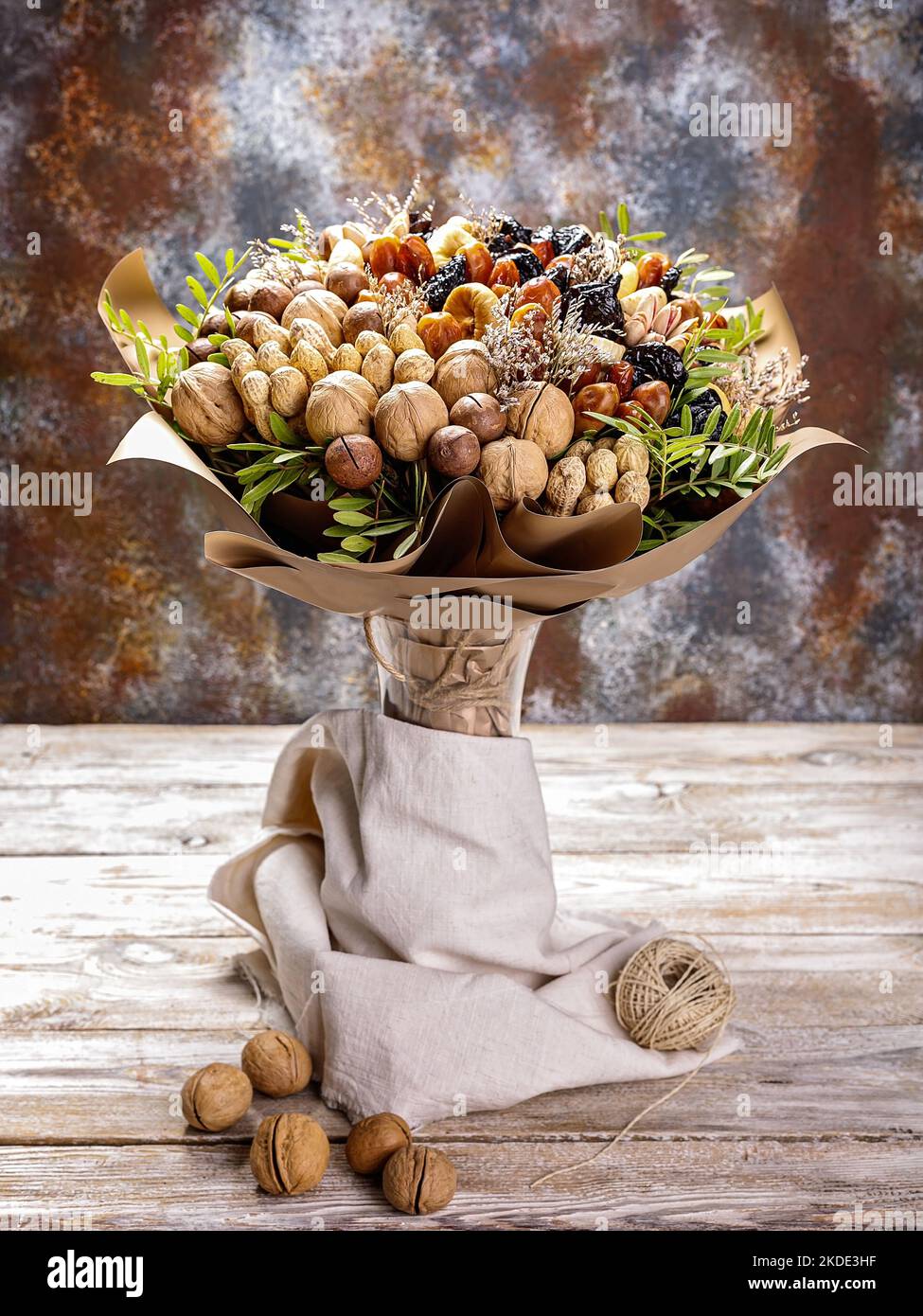 Gift bouquet of natural nuts and dried fruits. Ideas for original handmade gifts. Sweet healty nutrition. Vertical shot. Copy space Stock Photo