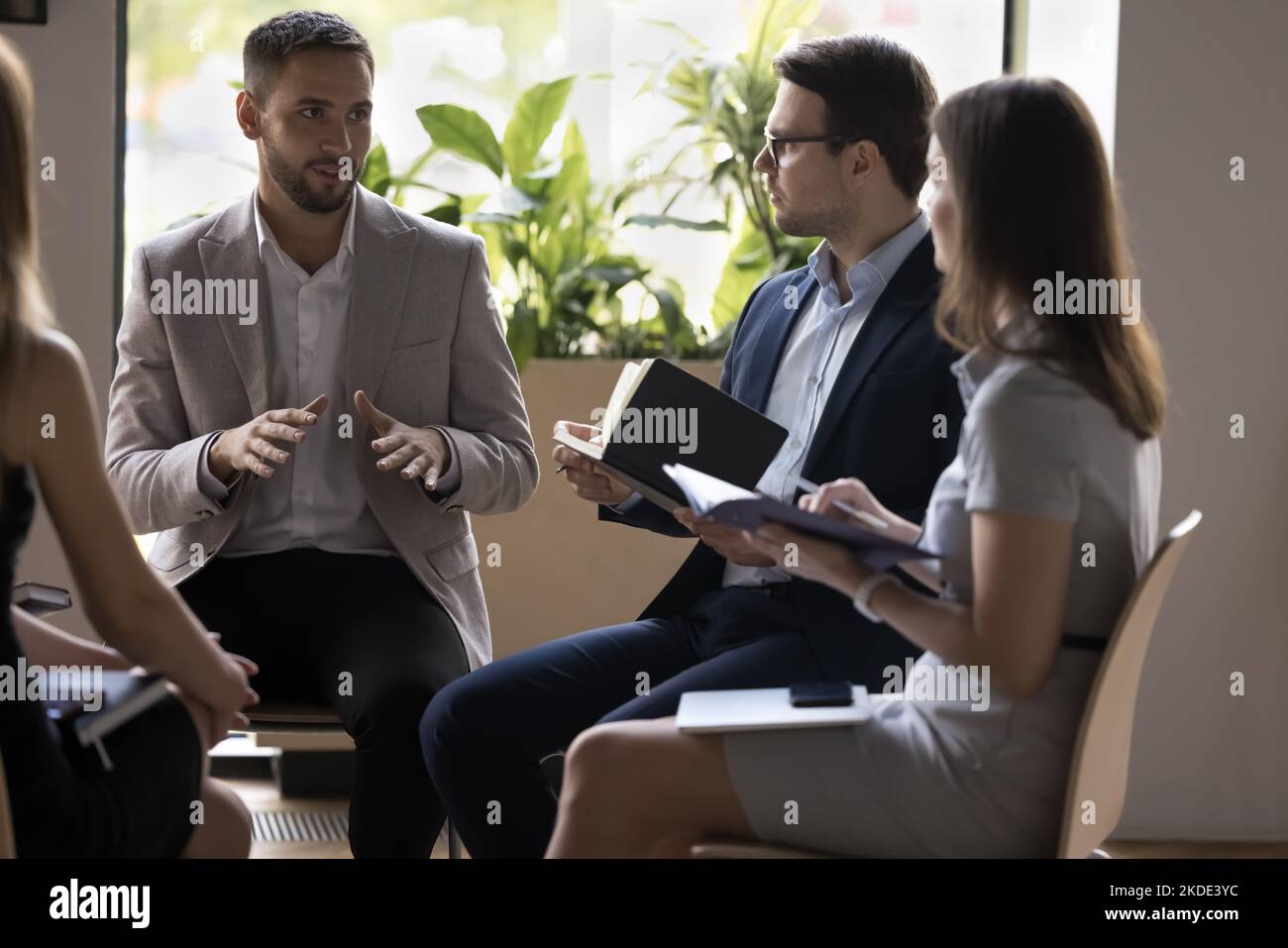 Group of businesspeople negotiating gathered in office Stock Photo