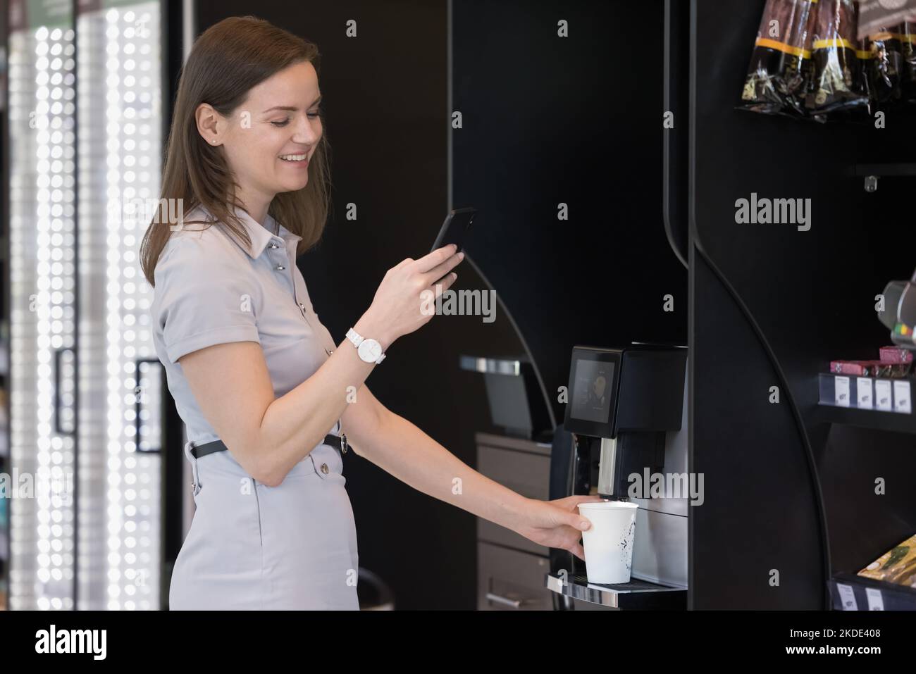 Businesswoman holding smartphone, prepare coffee using professional