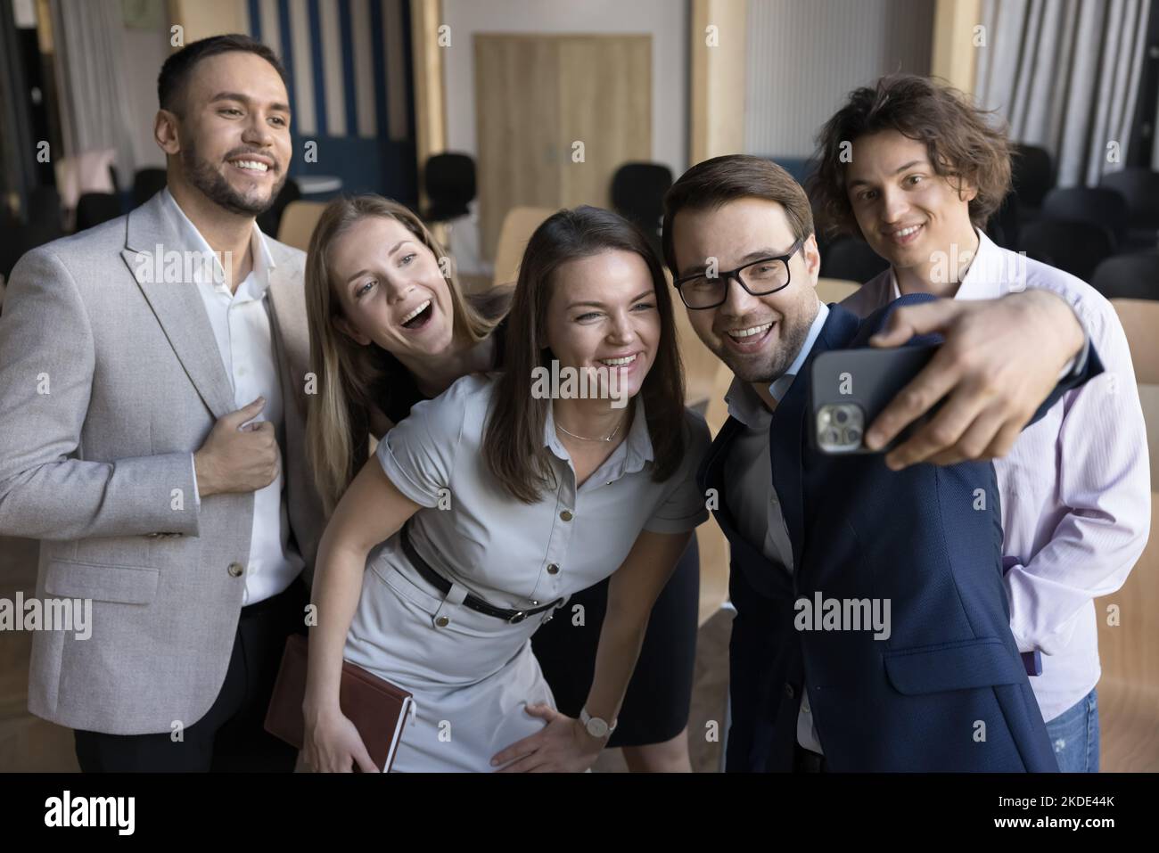 Happy businesspeople have fun at workplace make selfie using smartphone Stock Photo