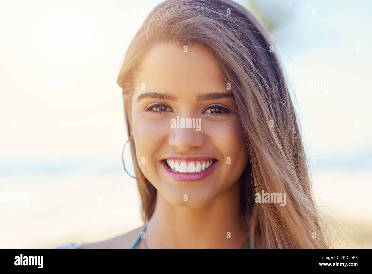 Enjoying summer sun. Portrait of an attractive young woman standing outside on a sunny day. Stock Photo