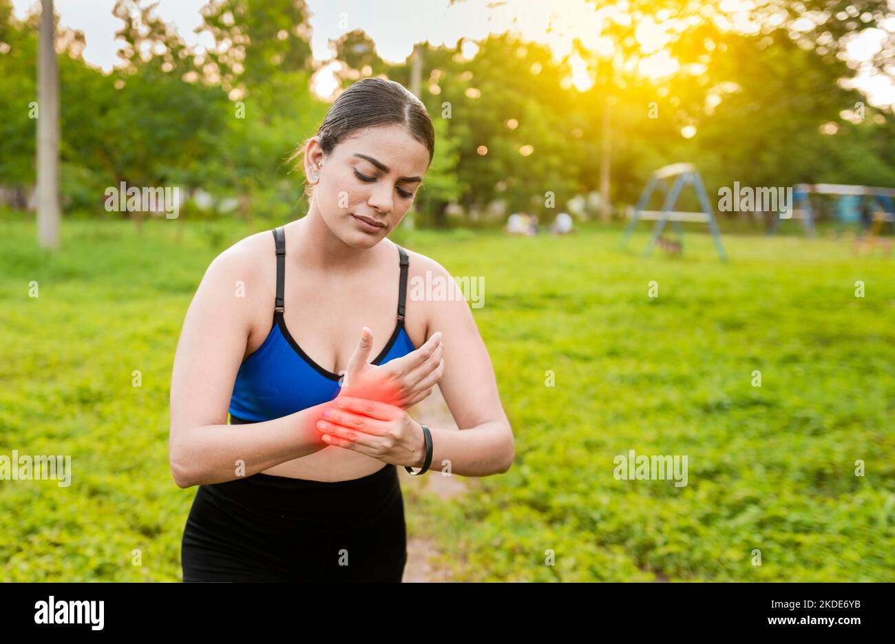 Fitness woman with wrist pain. Sport muscle injury concept. Runner girl with wrist pain outdoors. Concept of wrist pain and arthritis in the hands. Stock Photo