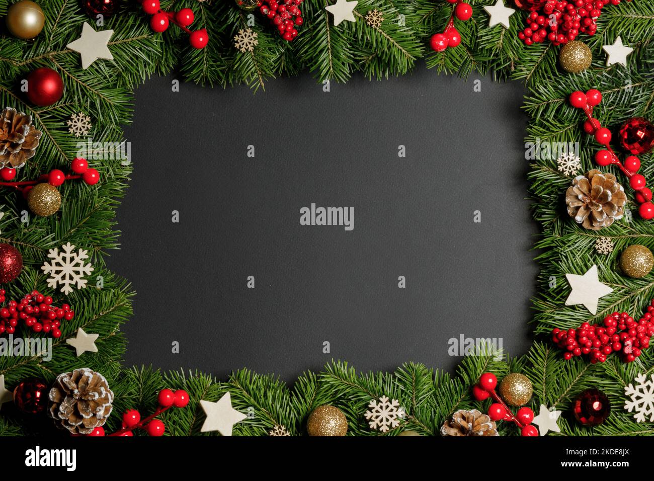 Natural fir Christmas tree border frame with decor on black, copy space ...