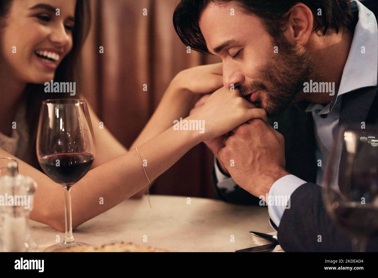 Your hands are so soft...a happy young couple enjoying a romantic dinner date at a restaurant. Stock Photo