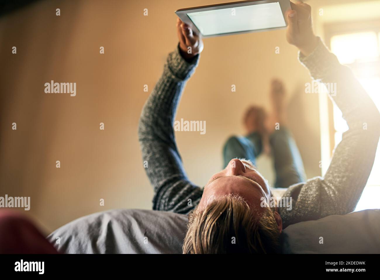 What the weekend is all about. a young man watching something on his digital tablet at home. Stock Photo