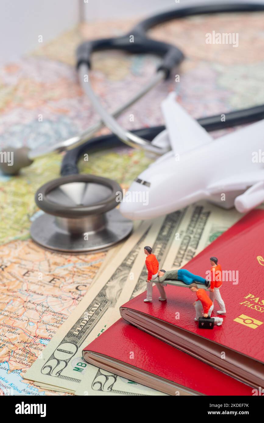 Miniature figures of paramedic personnel attending sick person in a foreign country concept. Stock Photo