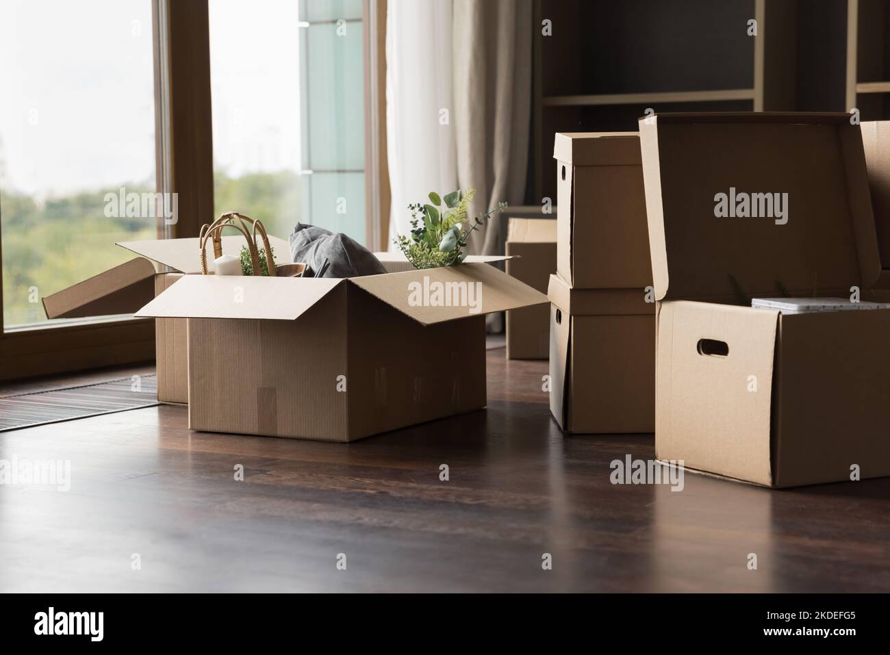 Big cardboard boxes with packed personal stuff stacked on floor Stock