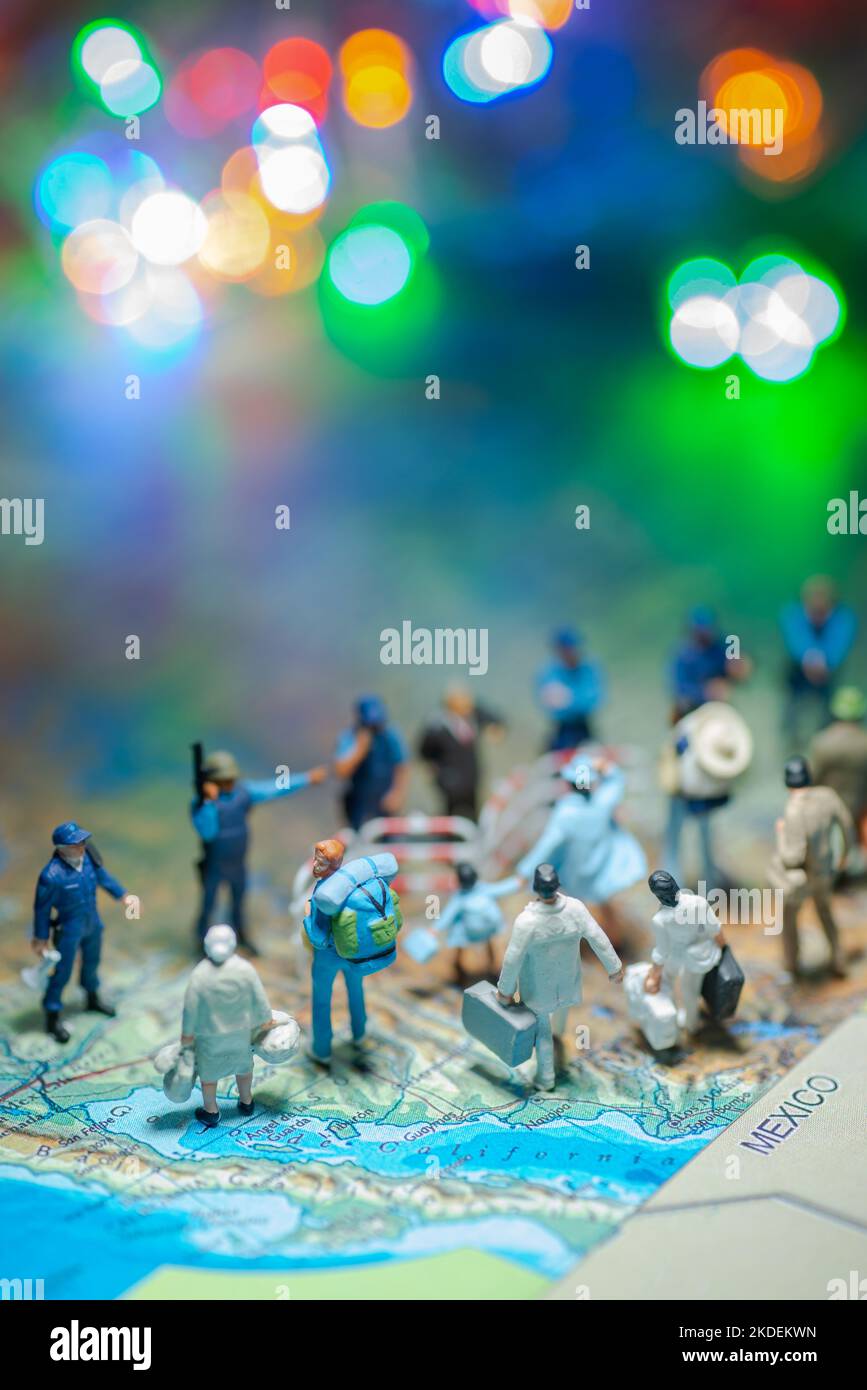 Miniature toy people concept US border patrols against a group of migrant from Mexico-blur bokeh light in the background. Stock Photo