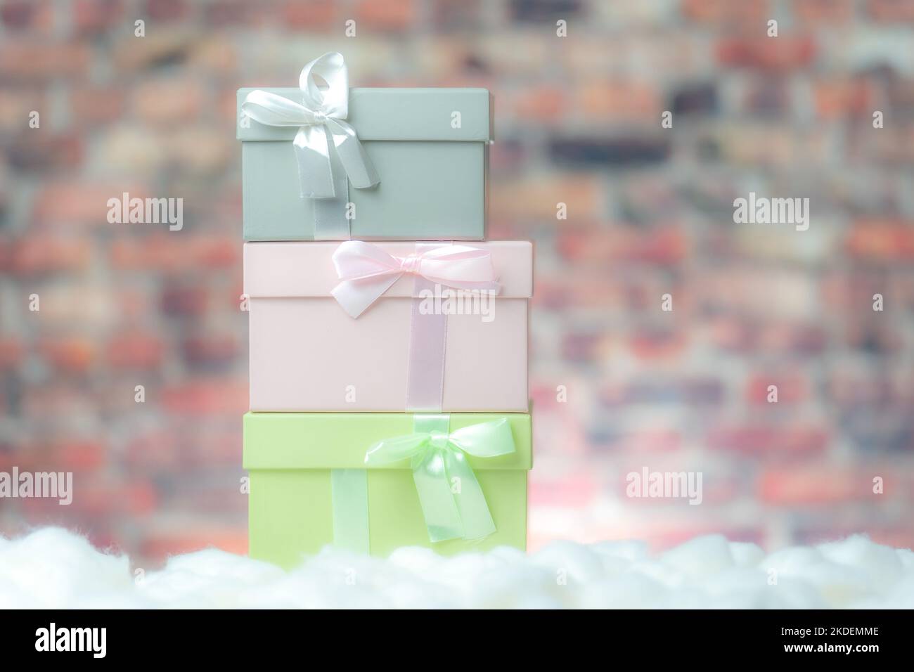 Colored gift box presents on white snow, background brick wall Stock Photo