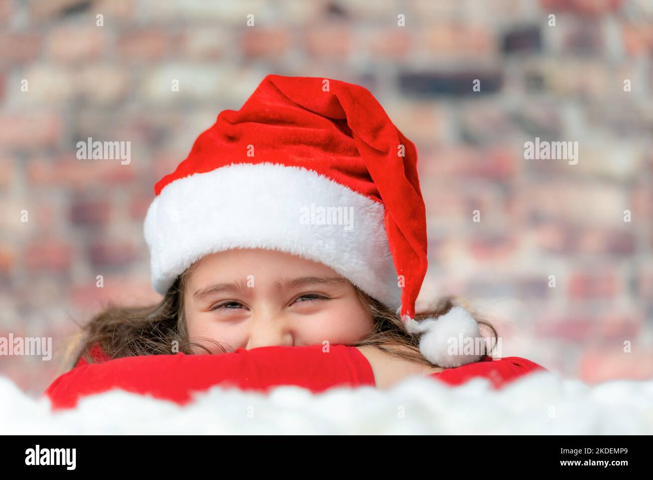 Child in Santa red cloth face close up with a big laugh or smile Stock Photo