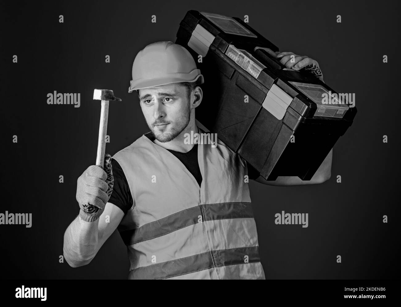Man in helmet, hard hat carries toolbox and holds hammer, blue