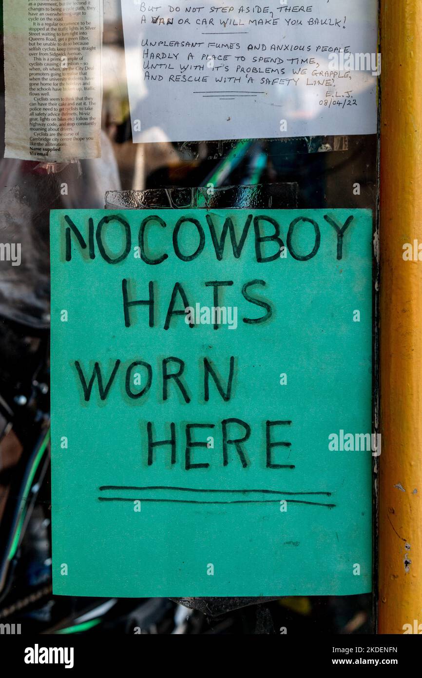 A sign in a shop window on Mill Road in Cambridge implies that the owner is honest and can be relied on. No Cowboy Hats Worn Here. Stock Photo