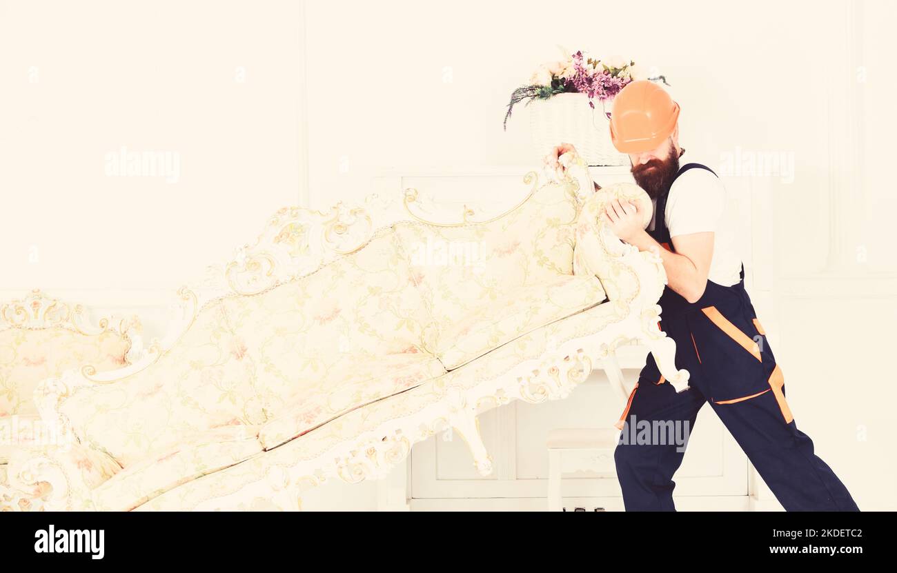 Delivery service concept. Loader moves sofa, couch. Courier delivers