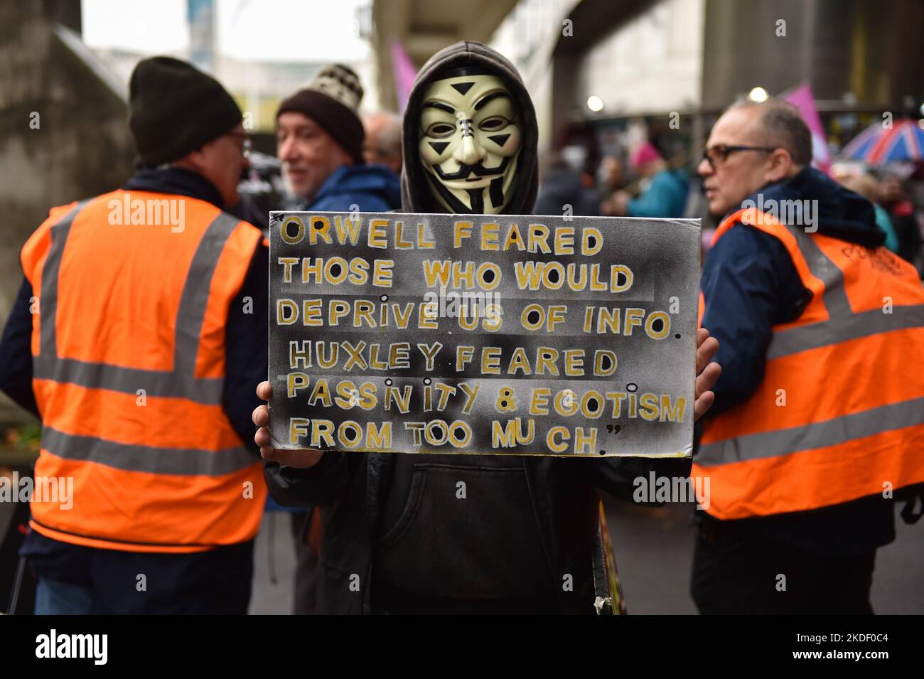 Demonstrator wearing Guy Fawkes-style masks seen at the rally. Anti government and anti-tories protesters gathered in Embankment and marched through Westminster to demand general election. Stock Photo