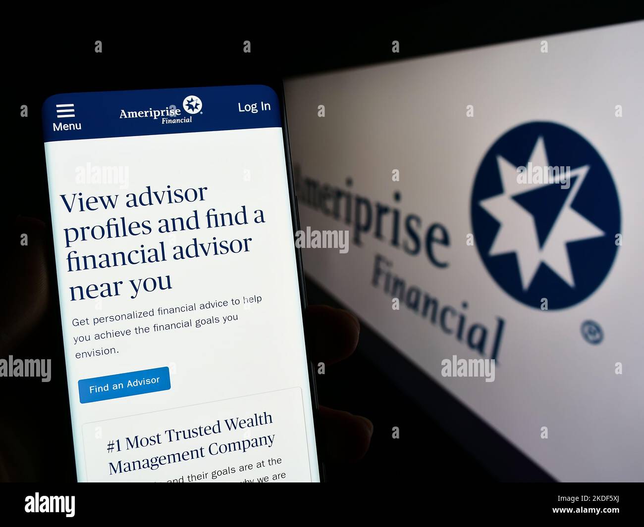 Person holding cellphone with website of US company Ameriprise Financial Inc. on screen in front of logo. Focus on center of phone display. Stock Photo