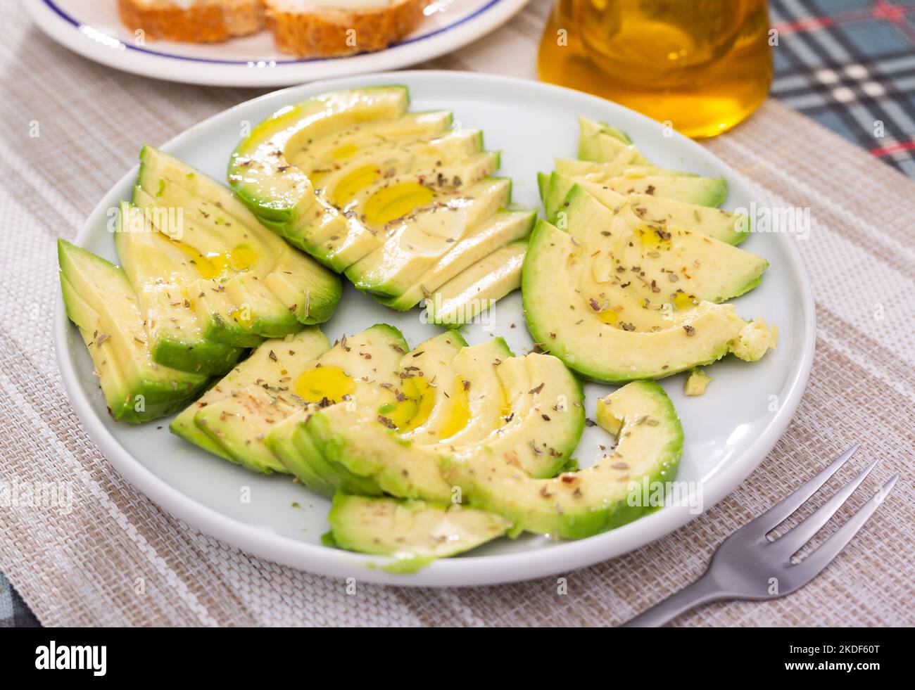 ripe avocado pulp cut into pieces sprinkled with lemon juice on a plate Stock Photo