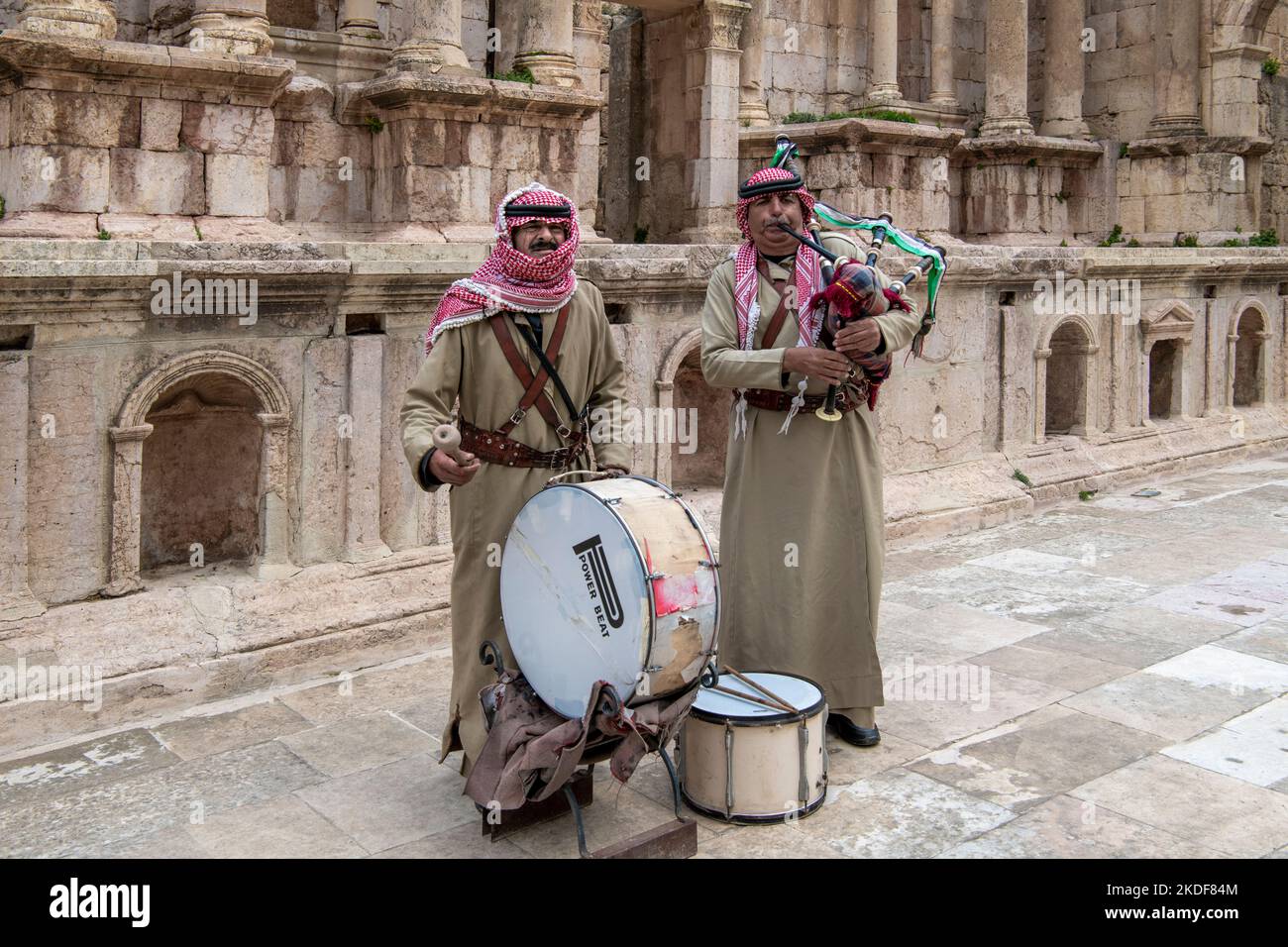 Two men in khaki uniform playing bagpipes and drums South Theatre Jerash Jordan Stock Photo