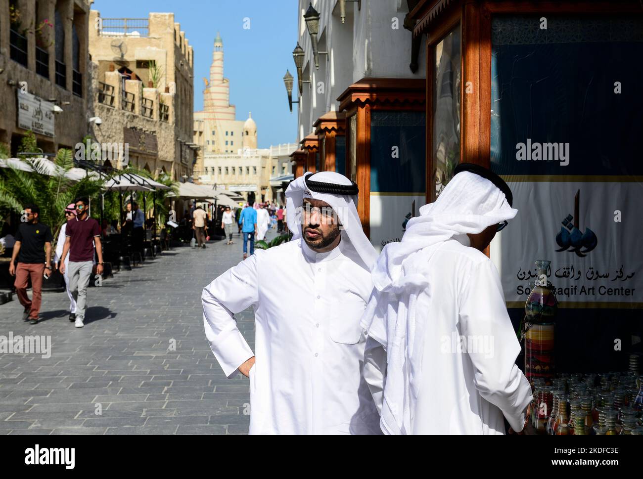 QATAR, Doha, bazar Souq Waqif and Fanar, behind tower of Qatar Islamic Culture Center, qatari man in Thwab / KATAR, Doha, Basar Souk Wakif und Moschee und FANAR (Qatar Islamic Cultural Center), Männer tragen ein langes weißes Gewand, Thawb, und einen weißen Kopfschutz Ghitra, der mit Igal, einem schwarzen Band, festgehalten wird Stock Photo