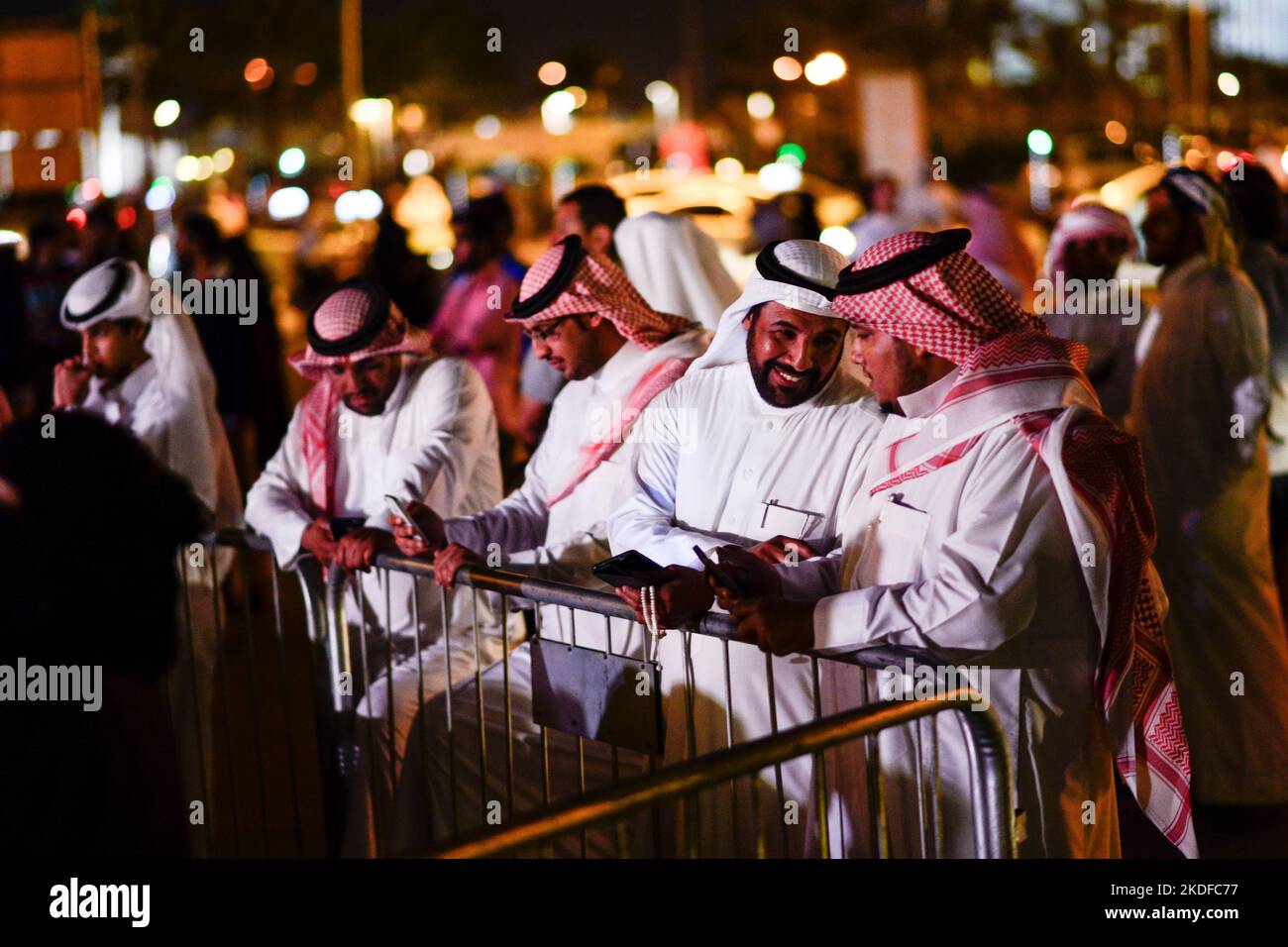 QATAR, Doha, Bazar Souq Waqif, qatari men at evening event / KATAR, Doha, Basar Souk Wakif, katarische Männer abends bei einer Veranstaltung, Männer tragen ein langes weißes Gewand, Thawb, und einen weißen Kopfschutz Ghitra, der mit Igal, einem schwarzen Band, festgehalten wird Stock Photo