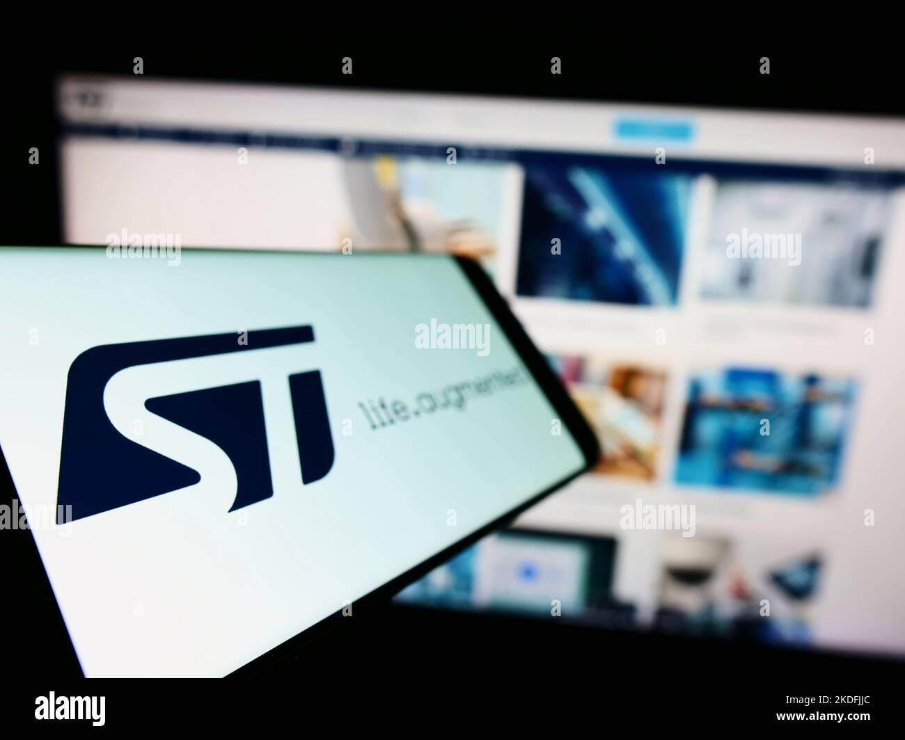 Smartphone with logo of semiconductor company STMicroelectronics N.V. on screen in front of business website. Focus on phone display. Stock Photo
