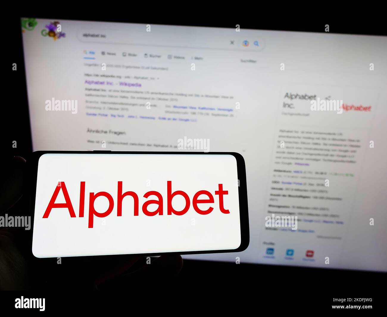 Person holding smartphone with logo of US holding company Alphabet Inc. (Google) on screen in front of website. Focus on phone display. Stock Photo
