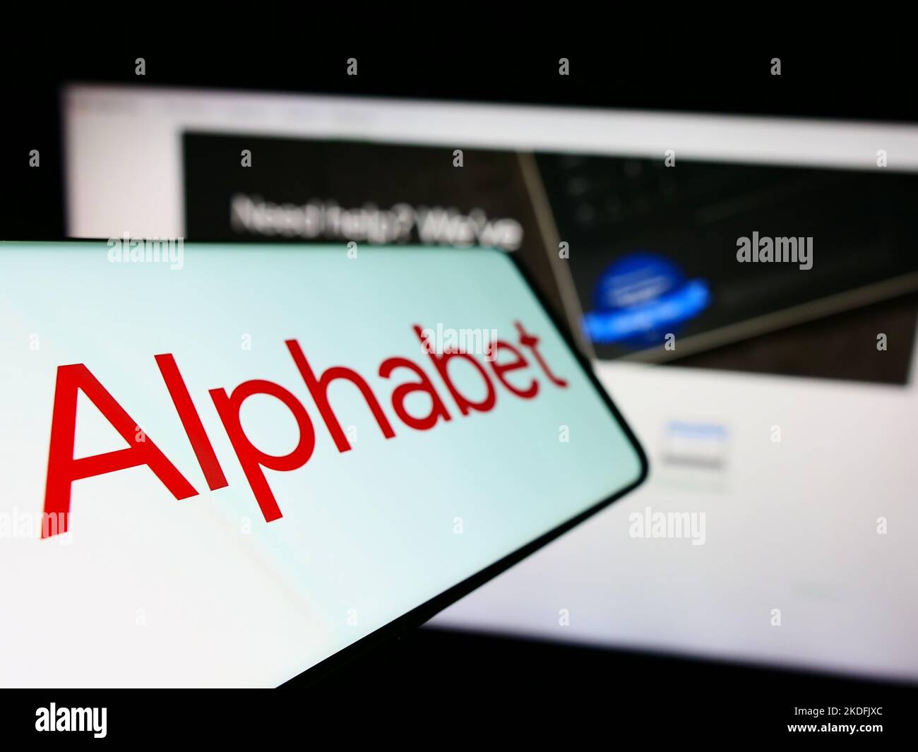 Mobile phone with logo of American holding company Alphabet Inc. (Google) on screen in front of business website. Focus on left of phone display. Stock Photo