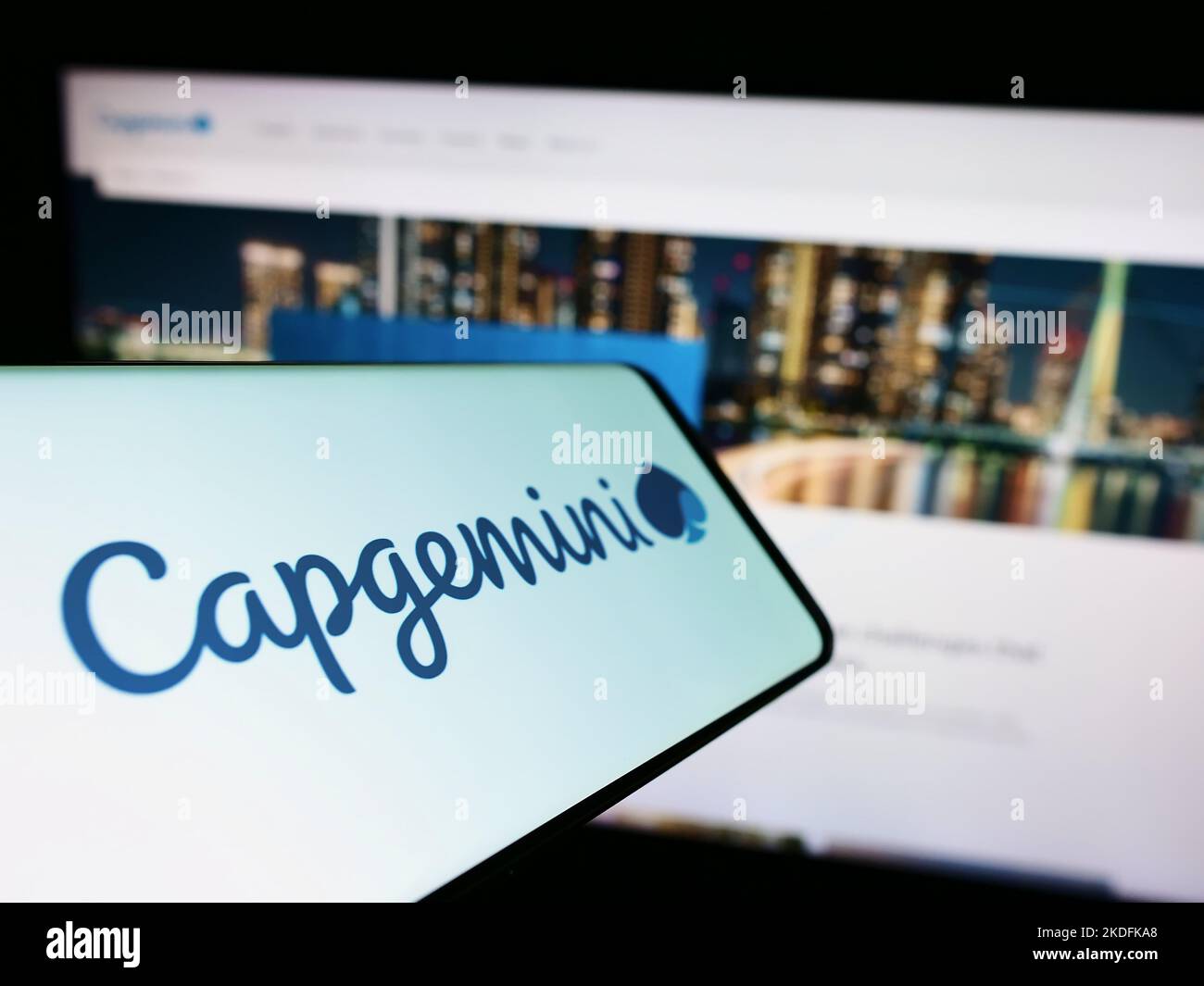 Cellphone with logo of information technology company Capgemini SE on screen in front of business website. Focus on center-left of phone display. Stock Photo
