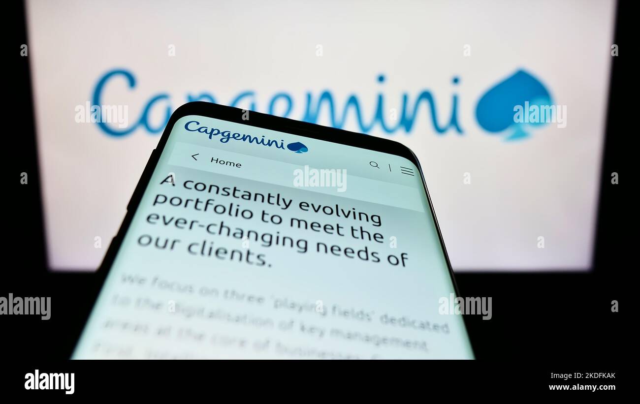 Mobile phone with webpage of information technology company Capgemini SE on screen in front of business logo. Focus on top-left of phone display. Stock Photo