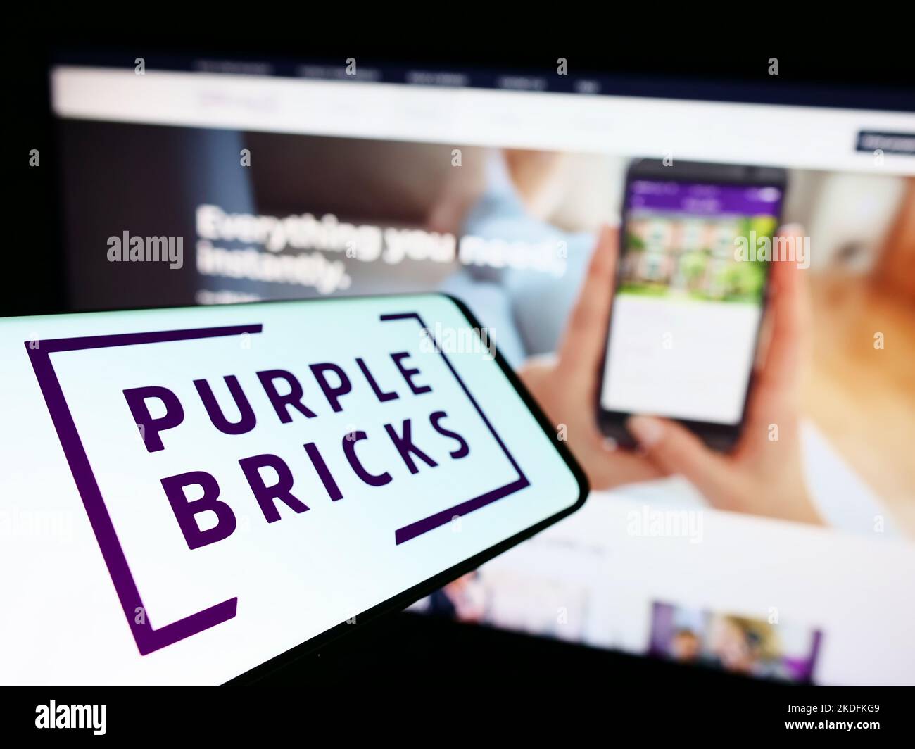 Smartphone with logo of real estate company Purplebricks Group plc on screen in front of business website. Focus on left of phone display. Stock Photo