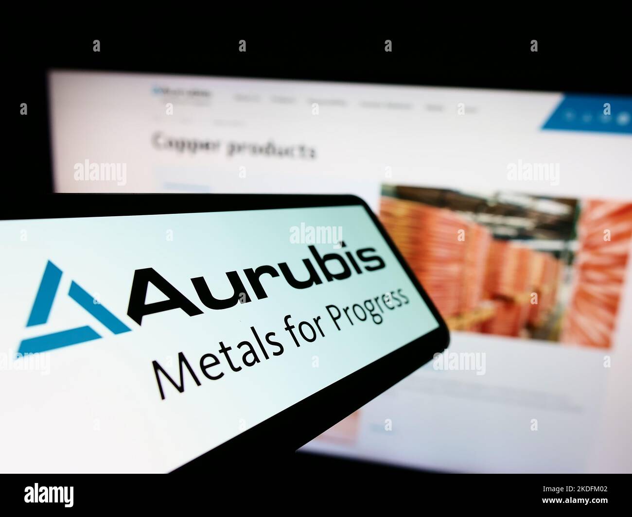 Mobile phone with logo of German copper company Aurubis AG on screen in front of business website. Focus on center-left of phone display. Stock Photo
