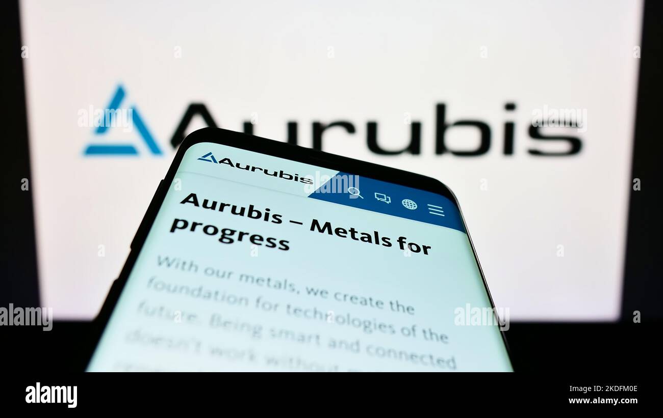 Smartphone with webpage of German copper company Aurubis AG on screen in front of business logo. Focus on top-left of phone display. Stock Photo