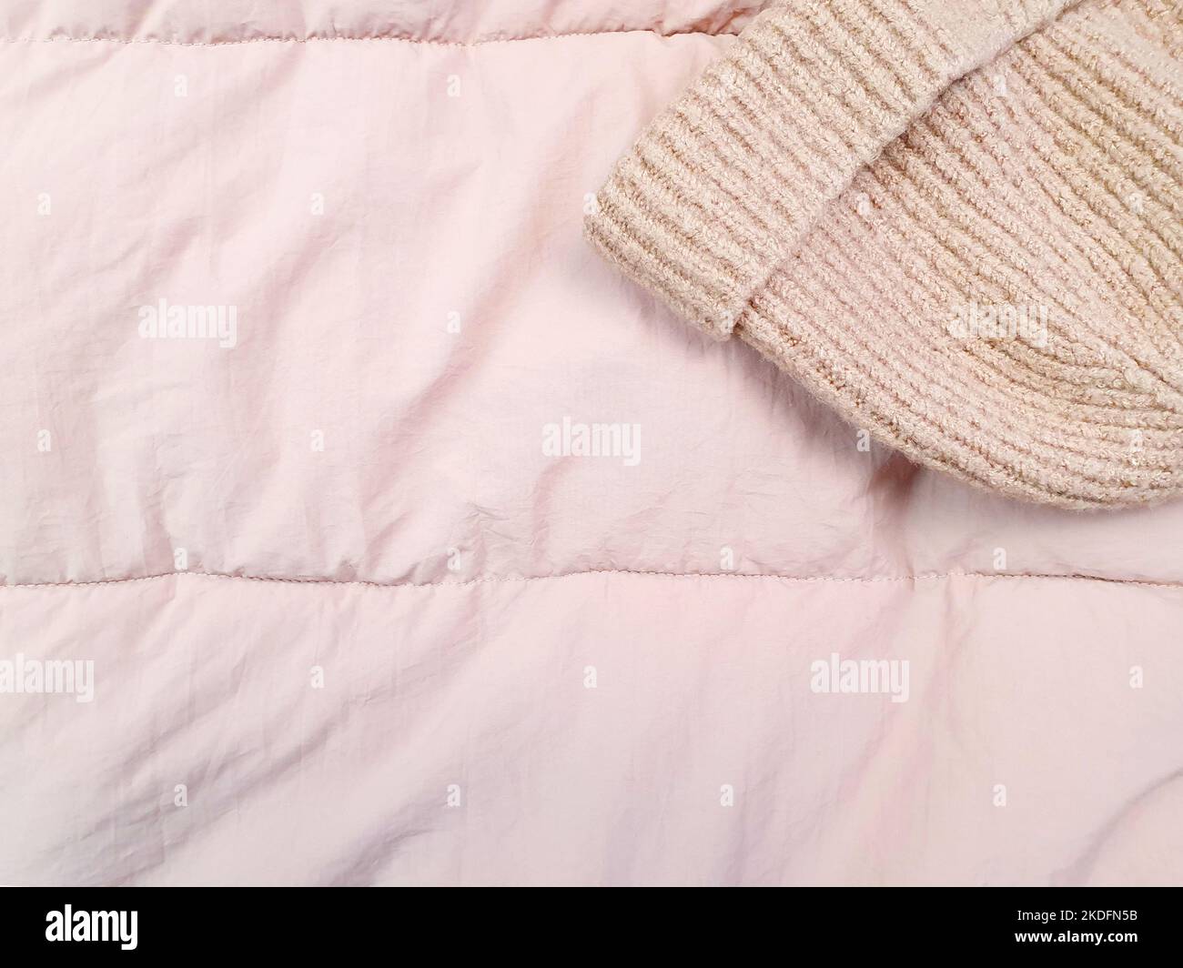pink knitted hat and down jacket fabric background, pink puffer jacket