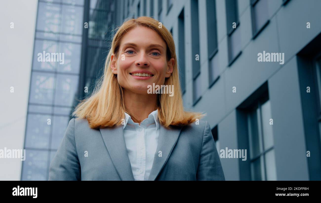 Female portrait close-up caucasian business woman standing outdoors looking away successful confident businesswoman satisfied client turns to camera Stock Photo