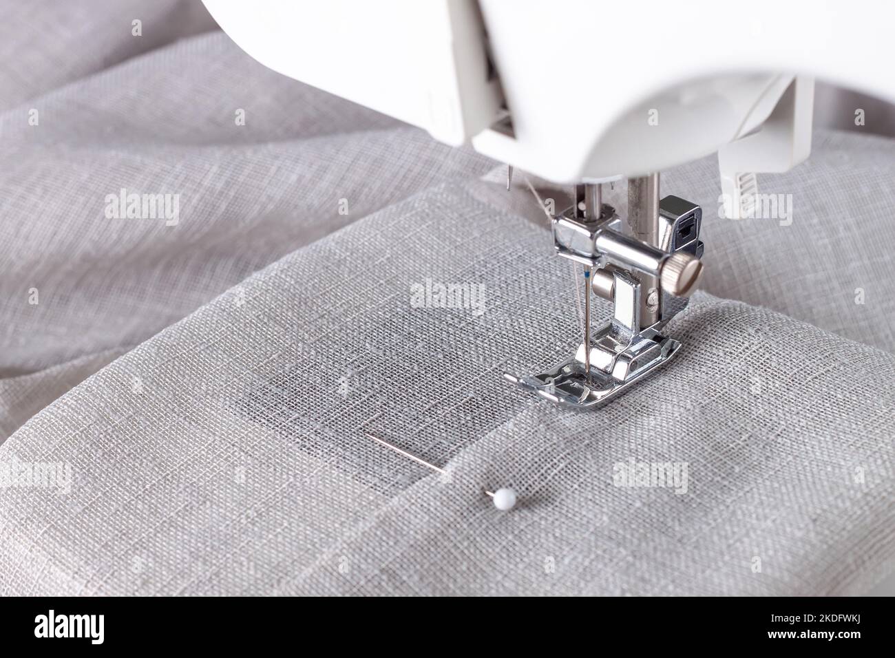 Modern sewing machine presser foot with linen fabric and thread ...