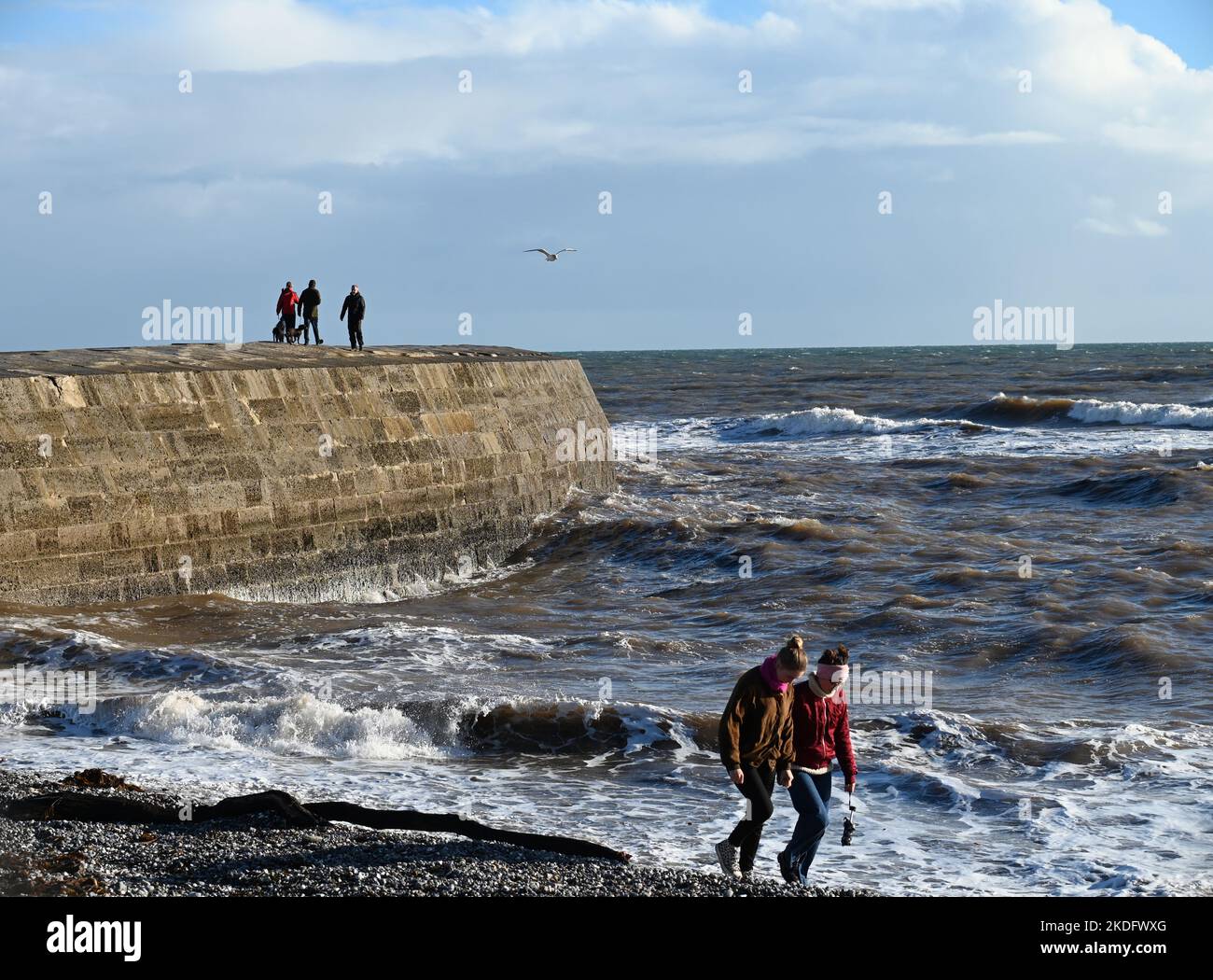 Lyme Regis, UK. 06th Nov, 2022. On a very windy afternoon people are seen walking on jetty with huge waves breaking over them. Picture Credit: Robert Timoney/Alamy Live News Stock Photo