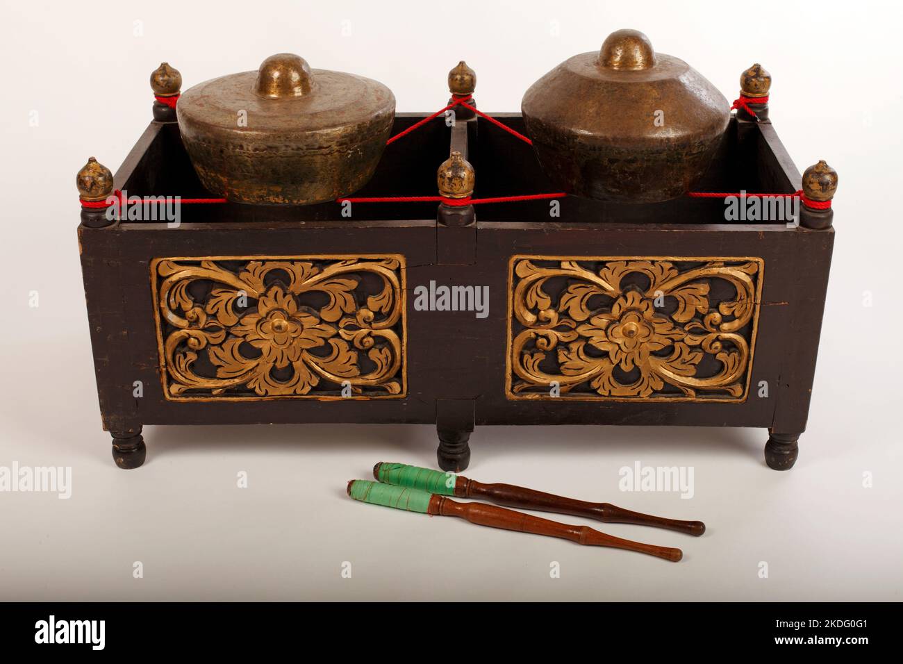 Bonang,  an Indonesian musical instrument used in the Javanese gamelan. Bronze gongs balanced on string with a decorative wooden frame. With beaters. Stock Photo